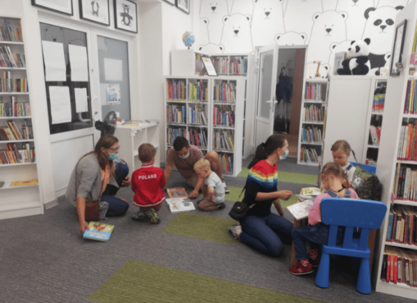Dzieci i rodzice przeglądają książki.