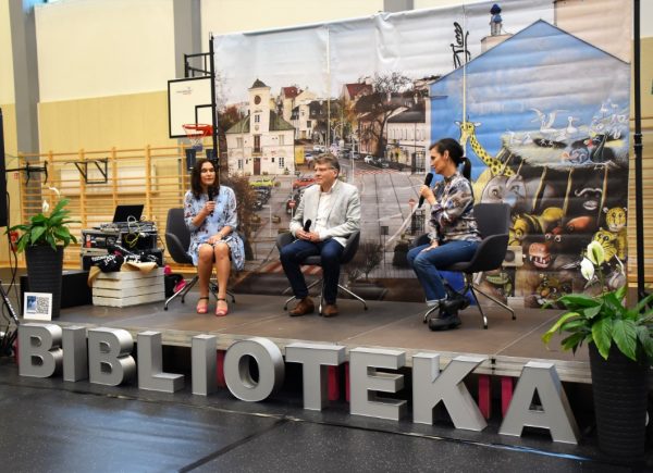 Na głównej scenie siedzą trzy osoby - Blanka Wyszyńska-Walczak, Jan Kerden i Olga Bończyk. Trzymają oni mikrofony i rozmawiają.