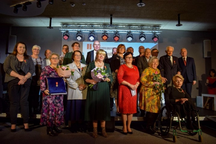 Zdjęcie przedstawia osoby, które odebrały Odznakę Honorową Powiatu Piaseczyńskiego. Odznaczeni pozują do zdjęcia i uśmiechają się.