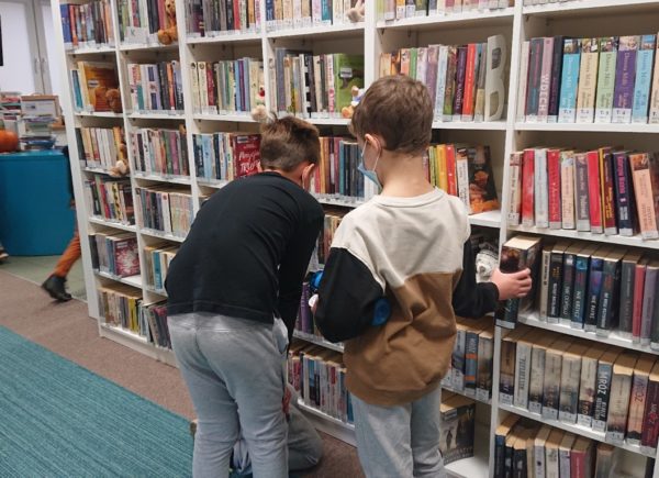 Dzieci przeglądają biblioteczne zbiory