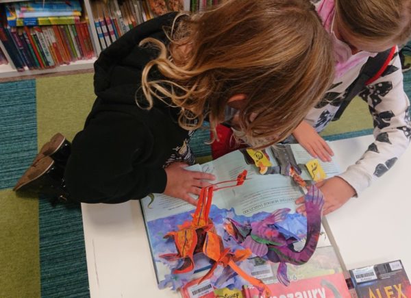Dzieci przeglądają biblioteczne zbiory