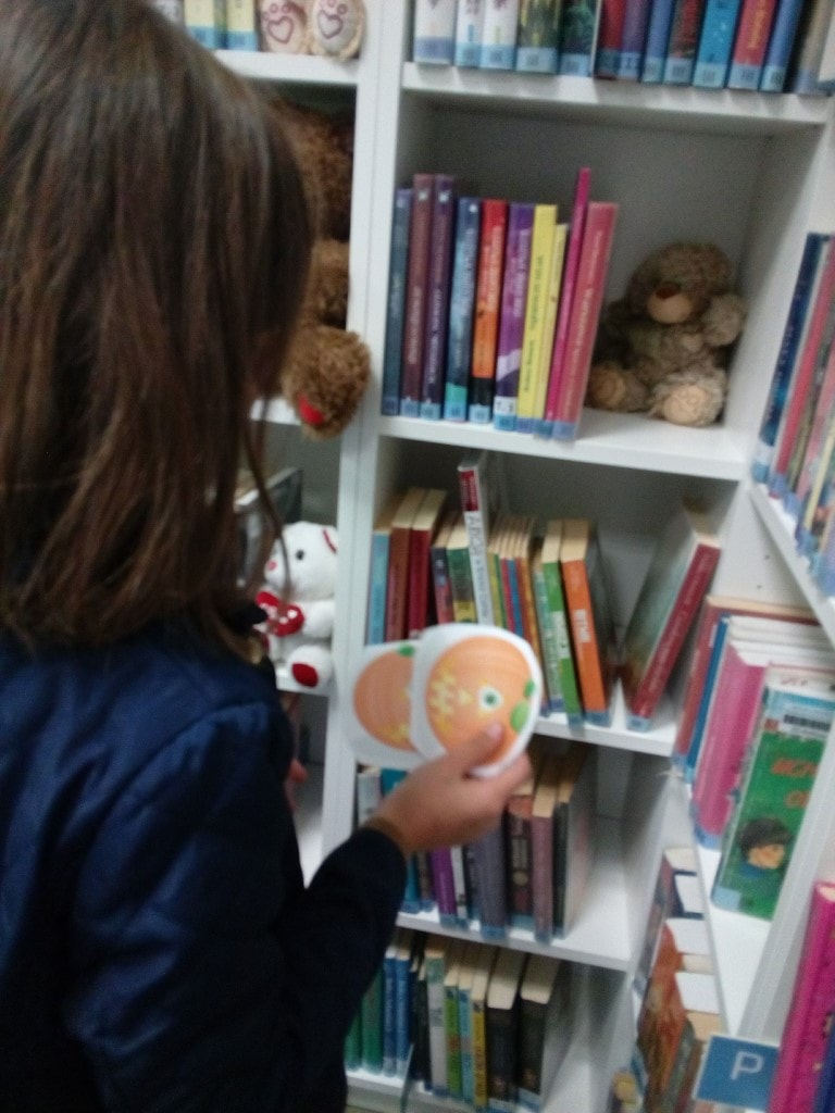 Dziewczynka poszukuje rysunków dyń w bibliotece