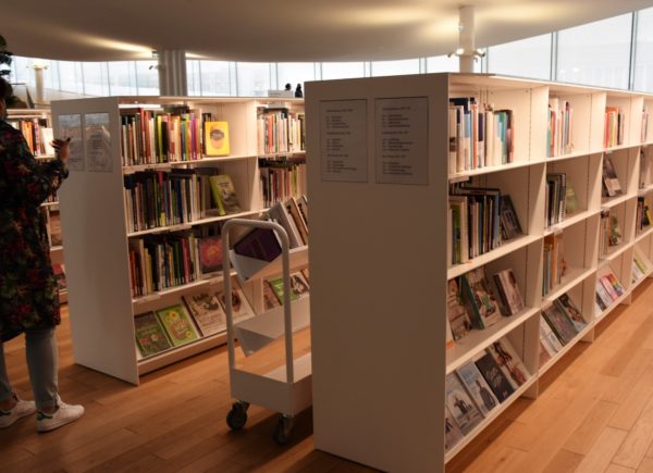 Zdjęcie przedstawia regały z książkami w bibliotece w Oodi.