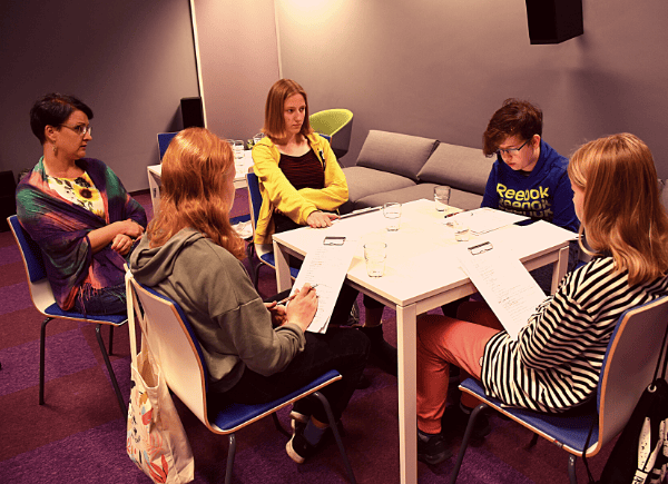 Warsztaty z Agnieszką Lis - dzieci siedzą przy stole i robią notatki