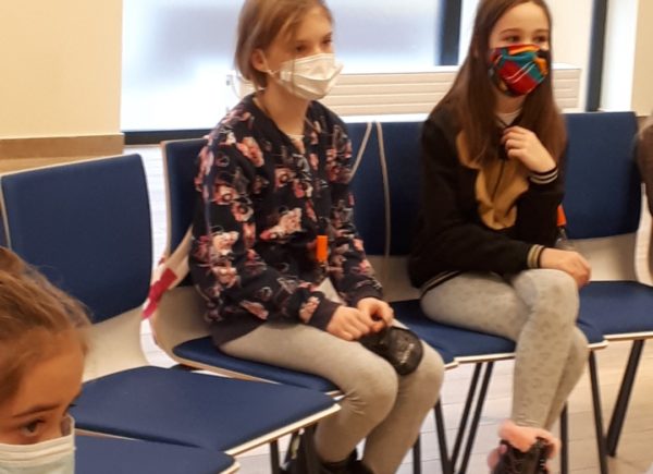 Na zdjęciu widać dwie dziewczynki zasłuchane podczas zajęć Piaseczyńskiego Uniwersytetu Dziecięcego