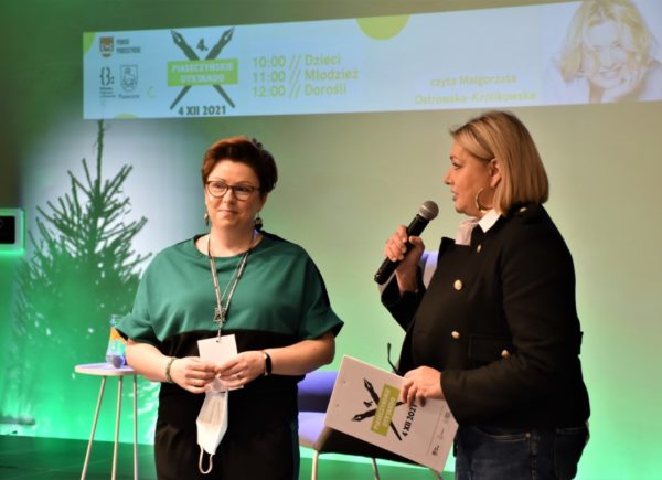 Wicedyrektor Biblioteki Głównej Sylwia Chojnacka-Tuzimek stoi na scenie wraz z Członkinią Komisji dyktanda.