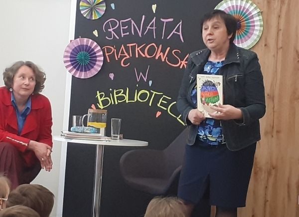 Renata Piątkowska zapoznaje dzieci z tematyką spotkania, trzyma w ręku książkę "Gdyby jajko mogło mówić"