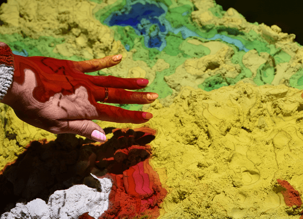 Zdjęcie dłoni nad piaskiem kinetycznym z eksponatu "Usyp mapę"