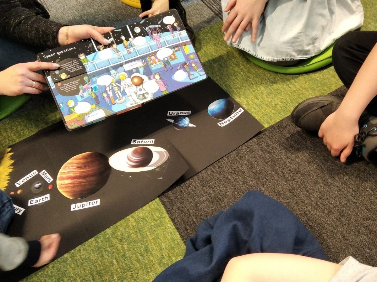 Dzieci oglądają angielskie książeczki o kosmosie
