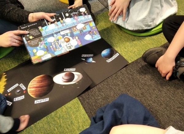 Dzieci ogladają angielskie książeczki o kosmosie