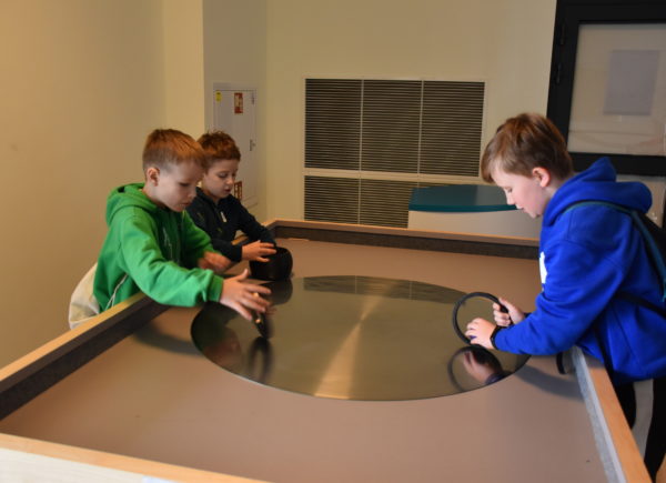 Studenci rozpędzają okrągłe obiekty na eksponacie "Obrotowy stolik"