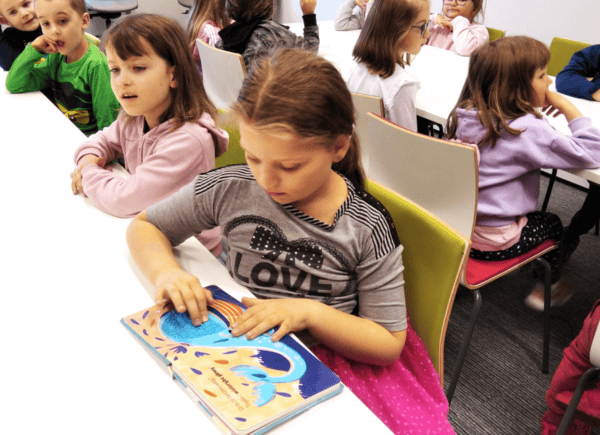 Dzieci oglądają książeczki dotykowe