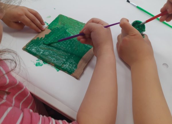 Dziecko maluje kawałek kartonu