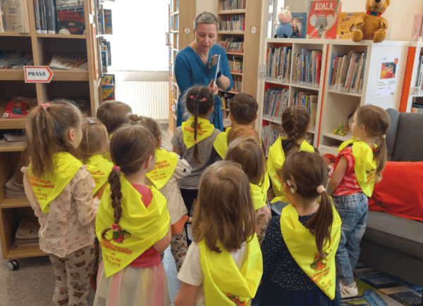 Bibliotekarka pokazuje dzieciom książki