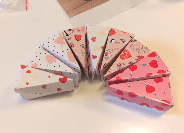 Dziewięć trójkątnych pudełeczek ułożonych w połówkę tortu