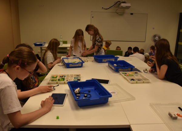Grupa dzieci buduje z klocków LEGO