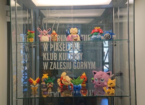Wystawa klockowych pokemonów w gablocie przed biblioteką