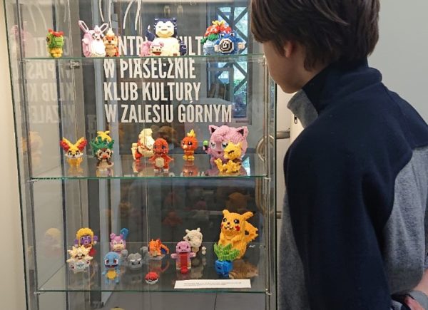Chłopiec ogląda figurki pokemonów