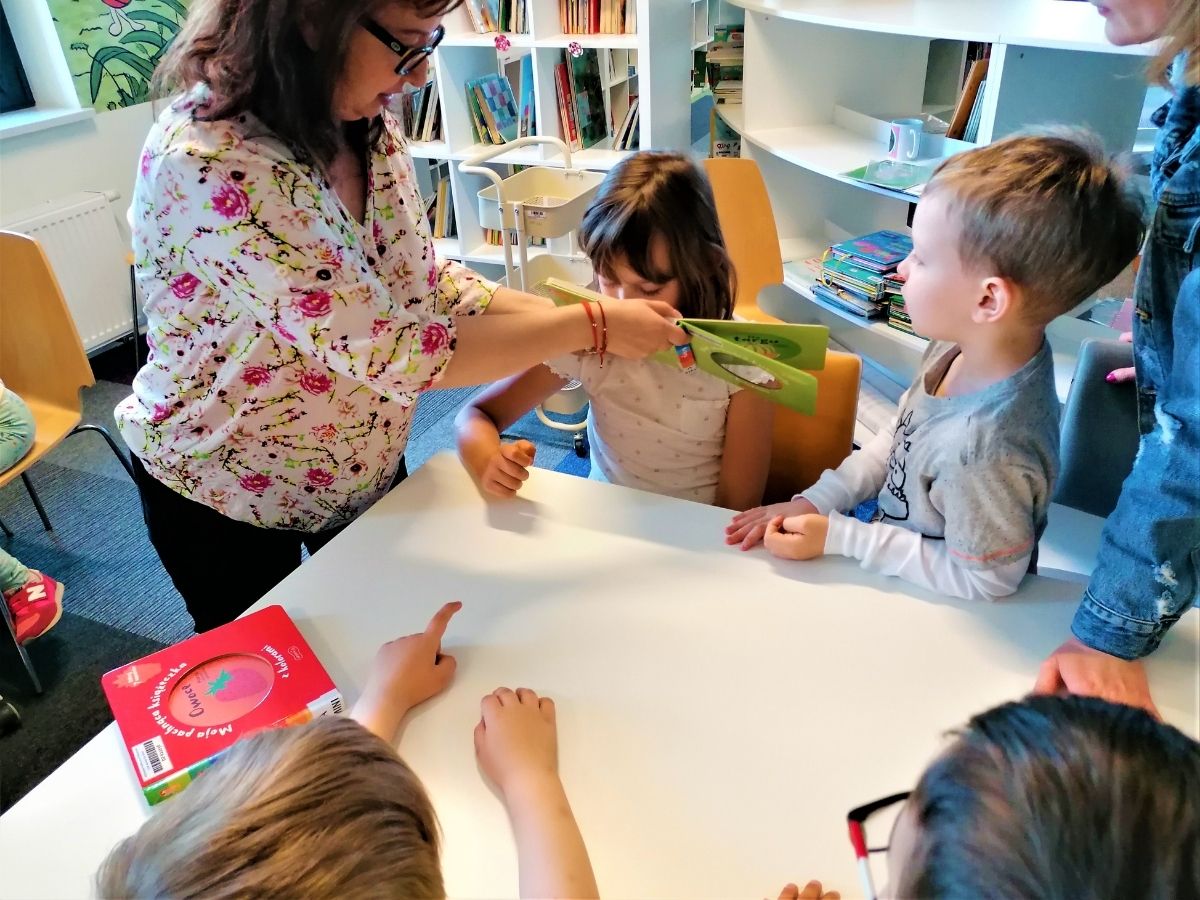 Przedszkolaki wąchają książeczki zapachowe