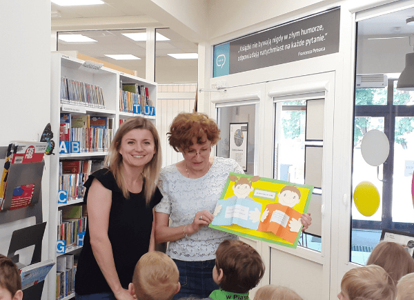 Dzieci wręczają w podziękowaniu za spotkanie dla bibliotekarek laurkę