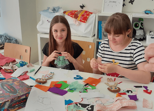Dziewczynki szyją kreacje dla filcowych modelek