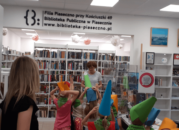 Bibliotekarka wita dzieci w bibliotece