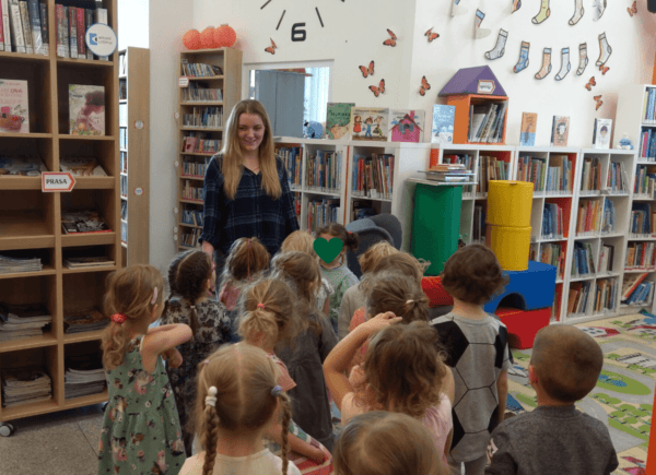 Bibliotekarka pokazuje dzieciom bibliotekę