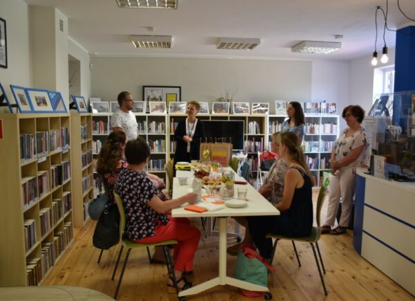 Dyrektorzy bibliotek publicznych siedzą przy stole, spotkanie rozpoczyna dyrektor Biblioteki Publicznej w Piasecznie