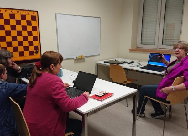 Kurs komputerowy dla seniorów. Uczestnicy siedzą przed laptopami