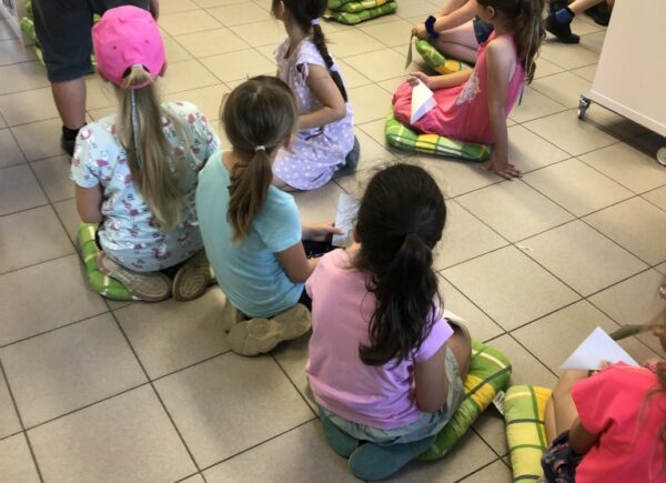 Dzieci słuchają podczas lekcji bibliotecznej