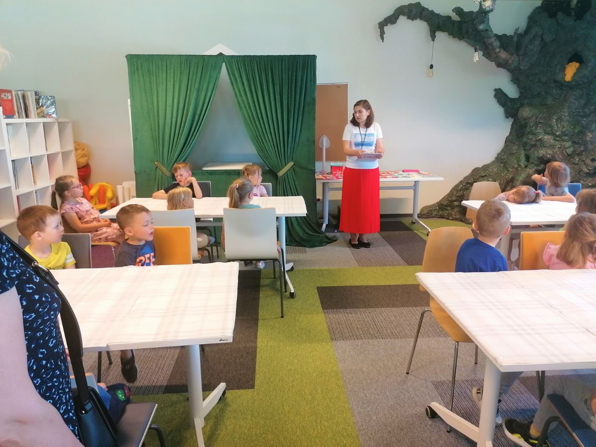 Bibliotekarka rozmawia z przedszkolakami o bezpieczeństwie w trakcie wakacji