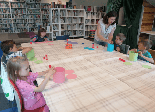 Dzieci sklejają bębenki z papieru