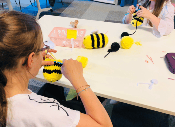 Dziewczynki robią na szydełku maskotki - pszczółki