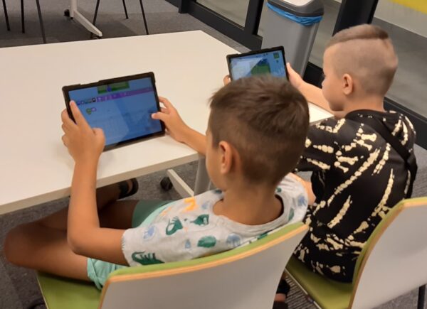 Dwóch chłopców tworzy aplikację na tablecie