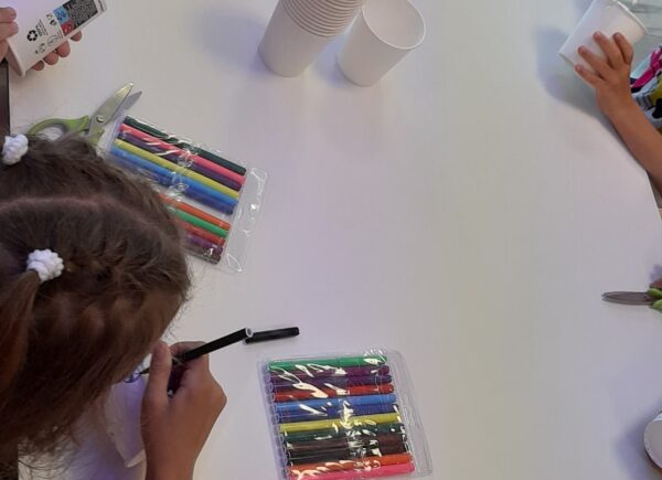 Dzieci kolorują papierowe kubeczki