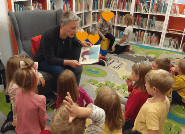 Bibliotekarka czyta dzieciom książkę.
