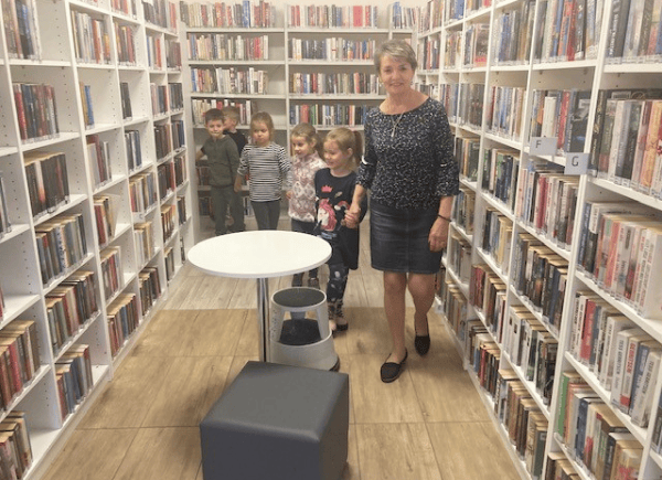 Bibliotekarka oprowadza dzieci po bibliotecznych labiryntach