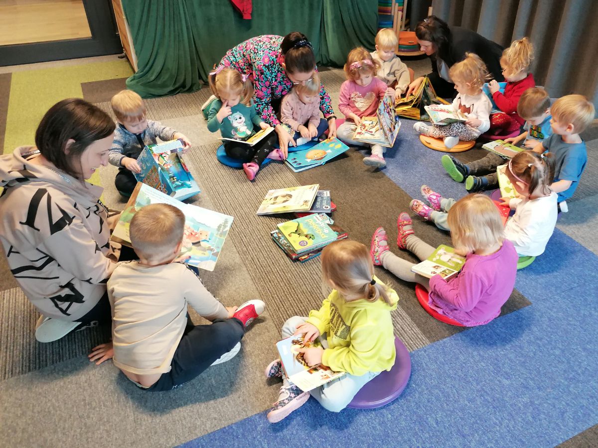 Przedszkolaki oglądają biblioteczne książeczki