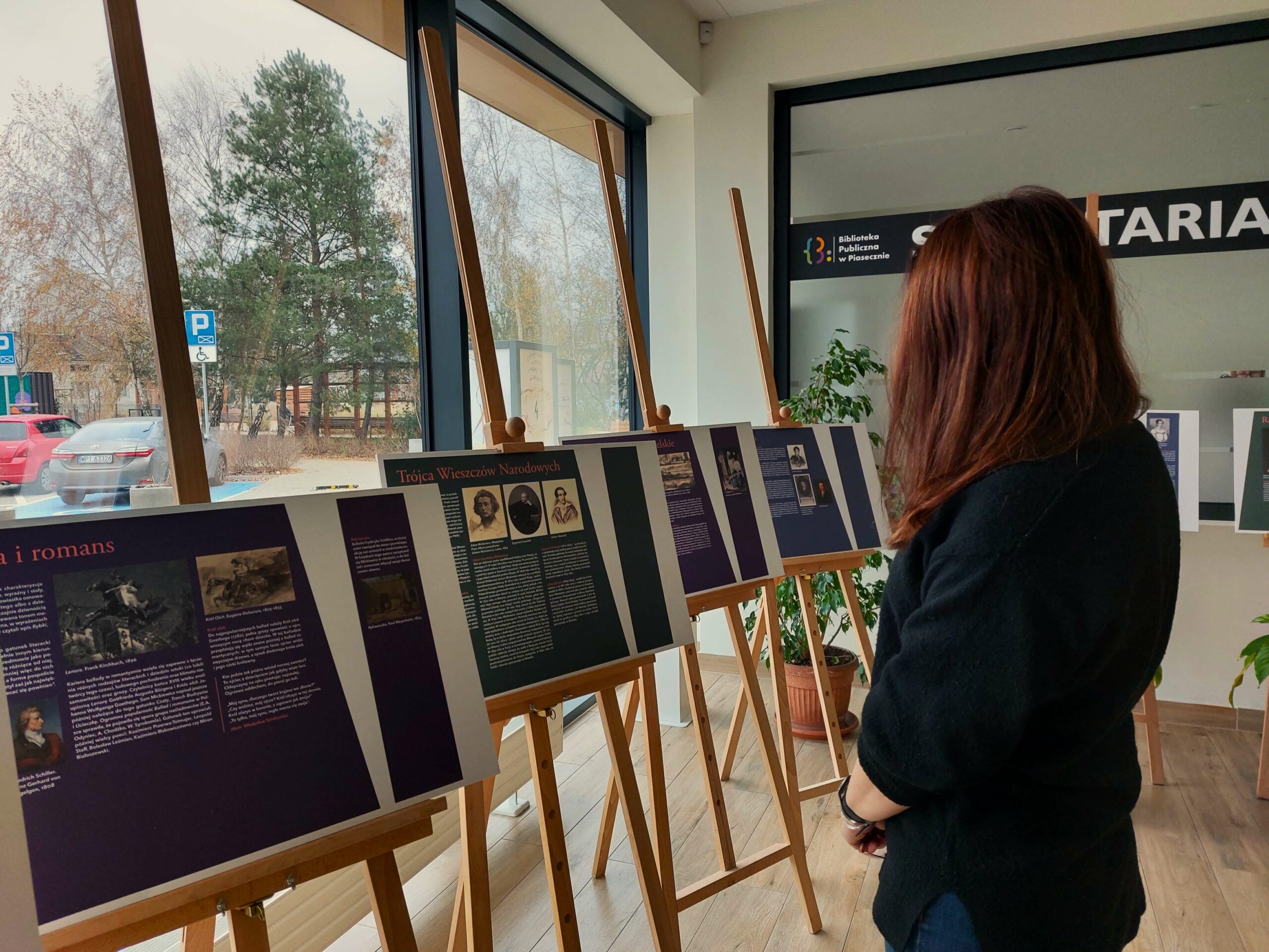 Na zdjęciu widoczna wystawa "Ballady i Romanse" z prawej strony stoi kobieta oglądająca ekspozycję.