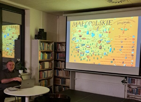 Robert Marcinkowski w trakcie prezentacji, na rzutniku mapa woj. małopolskiego