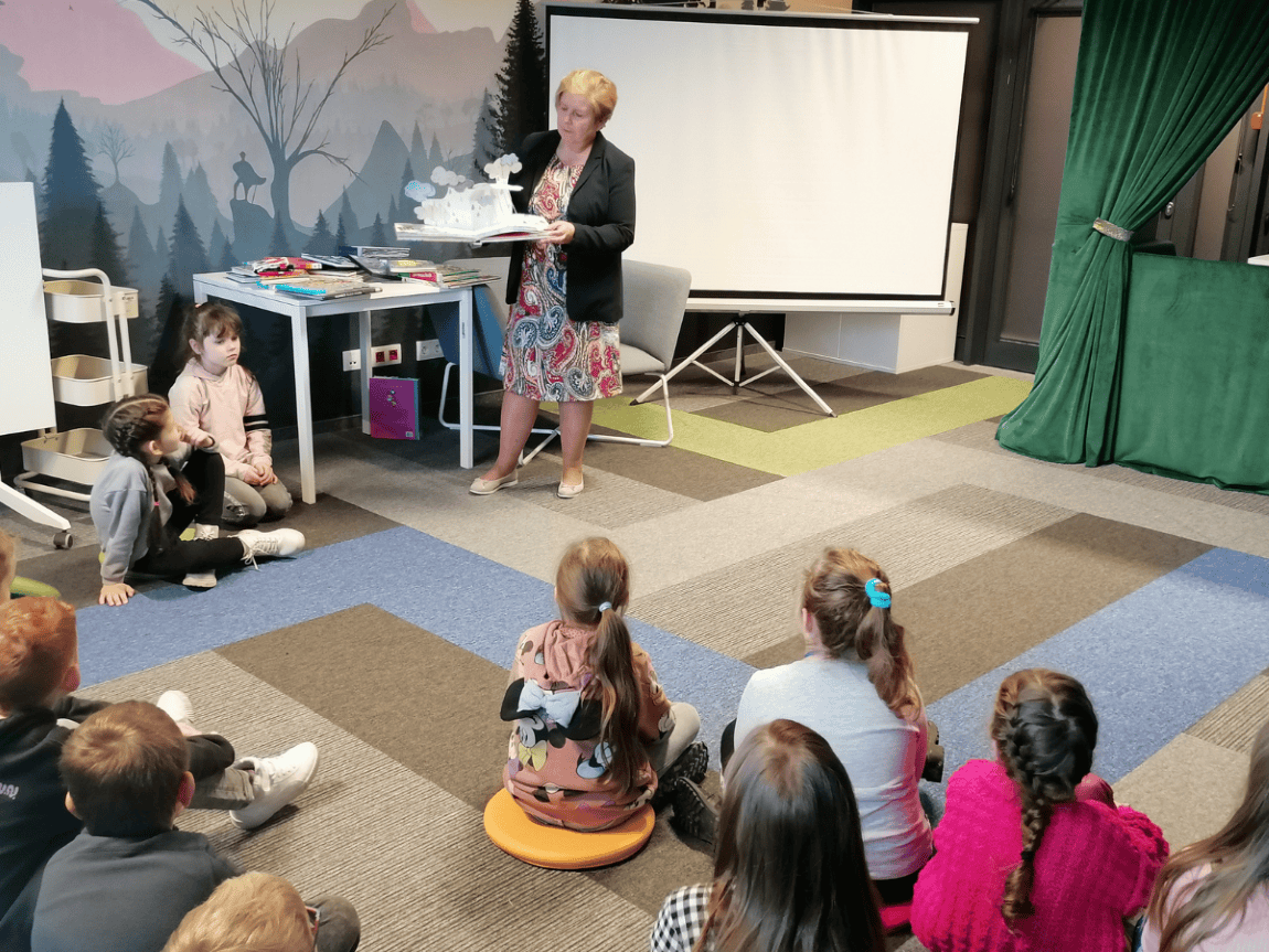 Pani Bibliotekarka prezentuje dzieciom książkę pop-up