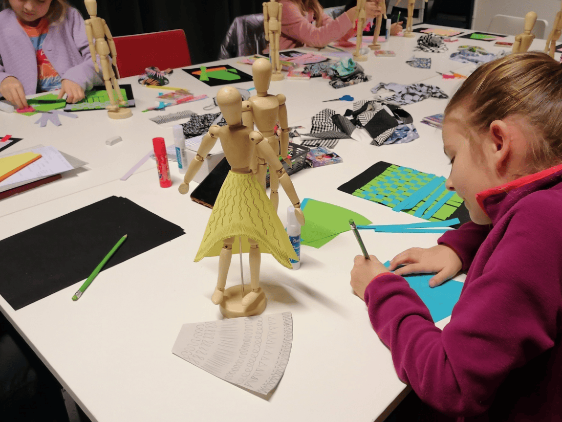 Na stole stoi manekin ubrany w spódnicę zaprojektowaną przez młodą projektantkę