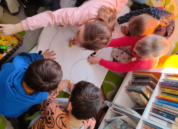 Dzieci wyklejają papierowego krasnala
