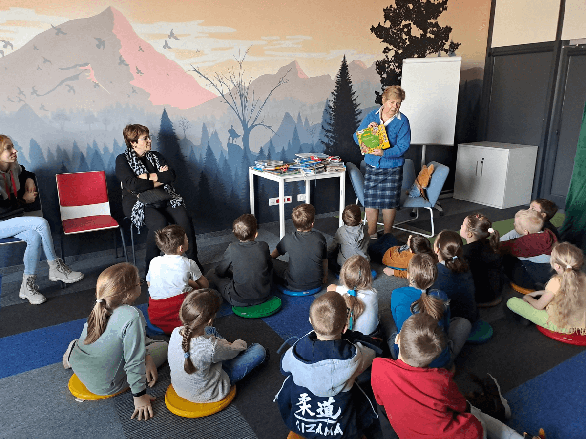 Kierowniczka Oddziału dla dzieci i młodzieży pokazuje uczniom książeczkę dźwiękową