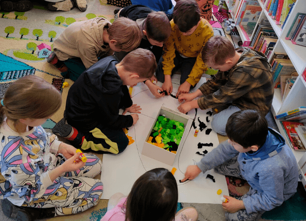 Dzieci wyklejają papierowego krasnala