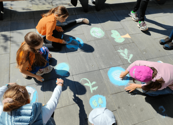 Dzieci malują kredą na chodniku