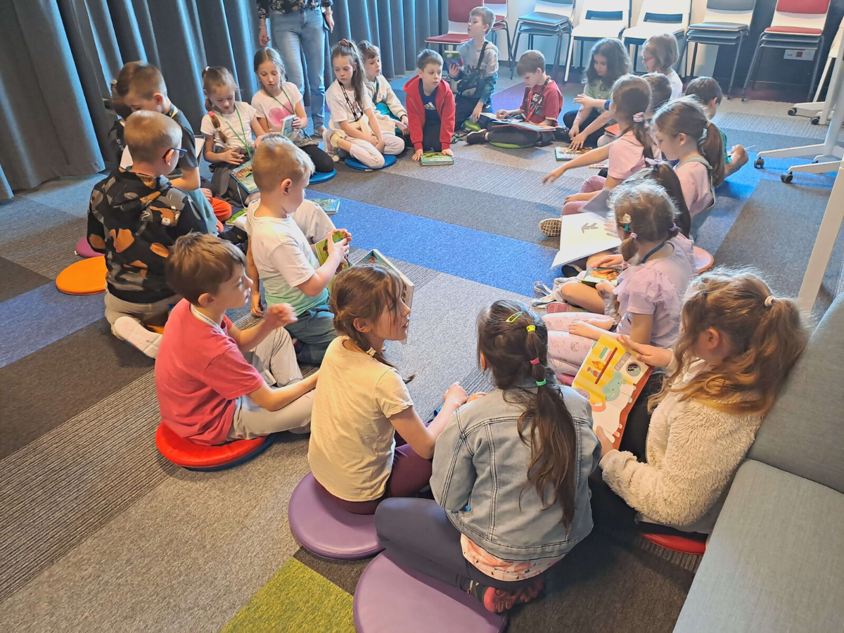 Dzieci podczas oglądania róznego rodzaju książek dostępnych w bibliotece
