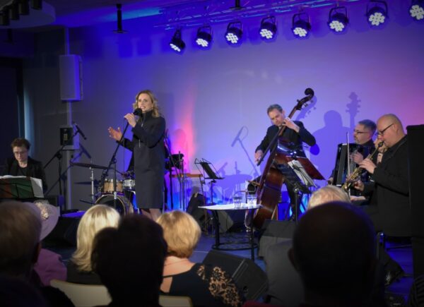 Na scenie Sali widowiskowej Anna Sroka – Hryń wraz z artystami koncertu.