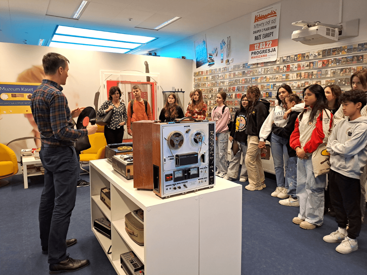 Uczniowie zwiedzaja część Muzeum Kaset z kasetami magnetofonowymi