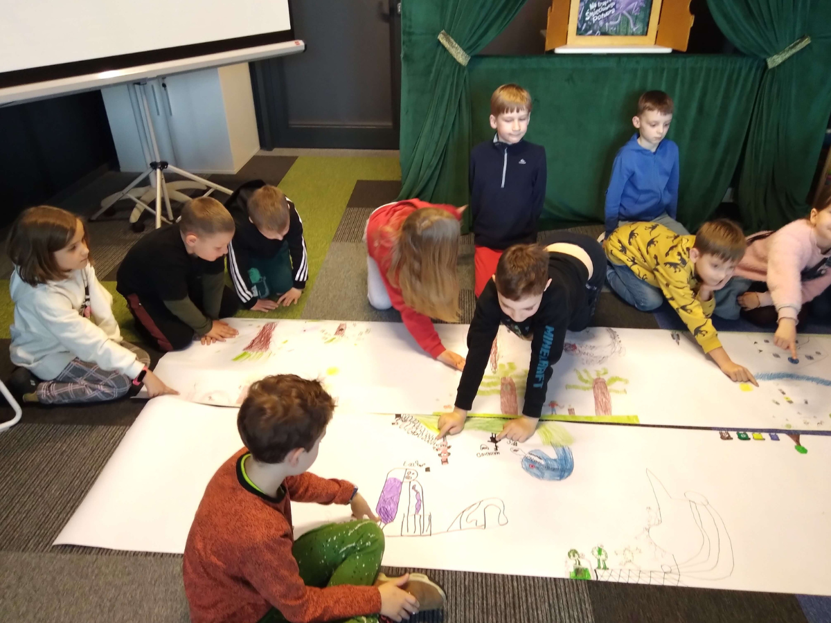Uczniowie kończą wspólną pracę nad plakatem o ekologii